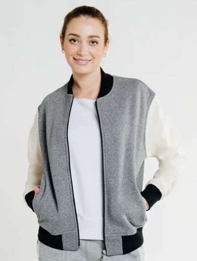 woman wearing gray varsity letterman jacket with white sleeves and black cuffs