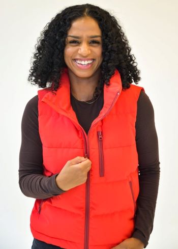 woman wearing bright orange puffer vest with full zipper