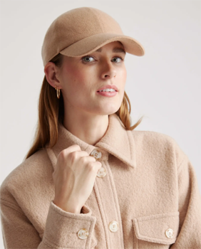 woman wearing cashmere baseball cap and matching camel-colored coat
