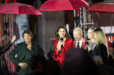 Tom Cruise and Mission Impossible stars under red umbrellas